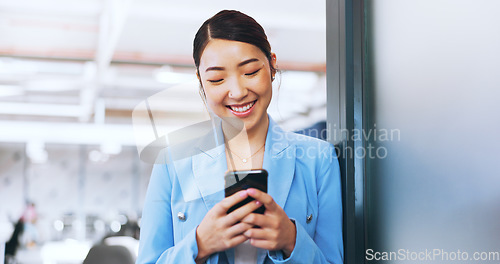 Image of Business woman, phone and typing in office on social media, internet browsing or texting. Tech, mobile and happy female from Japan on break with smartphone for messaging, web scrolling or networking.