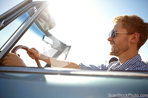 Image of Happy, young man and driving for summer vacation, road trip or journey for freedom in the outdoors. Male taking a drive in car with smile enjoying outdoor travel on a warm sunny day with sunglasses