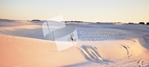 Image of Desert, motorbike and extreme sports of a man on sand dunes in Africa doing sport fitness. Driving challenge, beach adventure and cycling travel of a athlete in nature training for moto cross