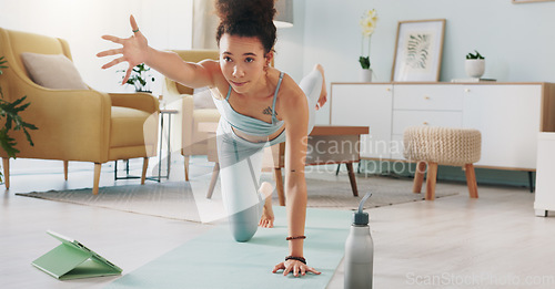 Image of Yoga, tablet and woman with online video for stretching exercise in the living room of her house. Girl with balance during fitness workout on the internet with tech in the lounge of her home