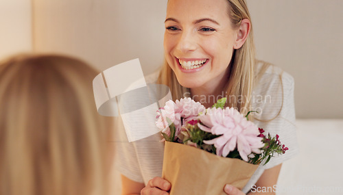 Image of Flowers, gift and happy with mother and girl for mothers day, birthday or congratulations in family home. Gratitude, smile and love with child giving bouquet to mom for present and celebration