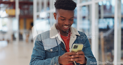 Image of Creative black man, phone and smile for texting, communication or social media at the office. Happy African American man enjoying online conversation, discussion or chat on smartphone for startup