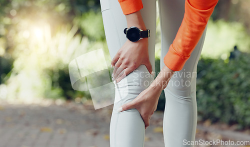 Image of Knee injury, pain or massaging woman or runner rubbing her leg during exercise or workout outside. Wellness, health and physical therapy during cardio training with a female athlete at the park.