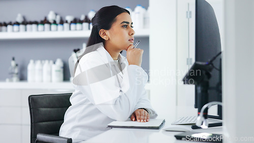 Image of Young scientist using a computer and microscope in a lab. Female pathologist analyzing medical samples while doing experiments to develop a cure. Microbiologist conducting forensic research