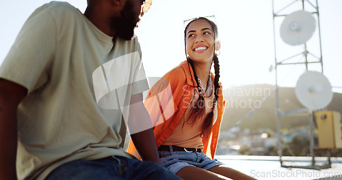 Image of Summer, couple and rooftop date with happy, smile and relax woman and man talking, bonding and laughing. Love, sunset and interracial guy and lady enjoying the view of the city while flirting outdoor