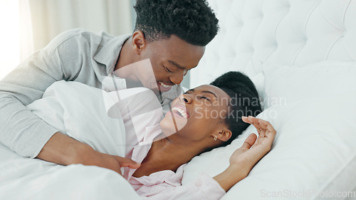 Image of Kissing, morning and couple in bed waking up together in a luxury hotel bedroom or getaway honeymoon retreat. Love, care and happy man, woman or black people cuddle under blankets bonding on weekend