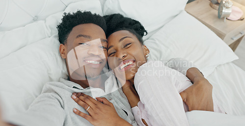 Image of Selfie influencer couple in bed and portrait smile for fun indoor weekend or waking up together in the morning. Fun, happy black people in bedroom and a POV portrait photo for social media content