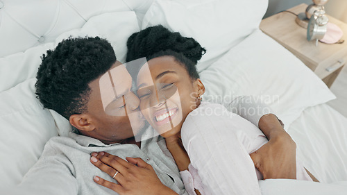 Image of Selfie, kiss and happy influencer couple vlogging their honeymoon while lying in bed to love and relax together at home. Portrait of a loving black man and woman having romantic moment in the morning