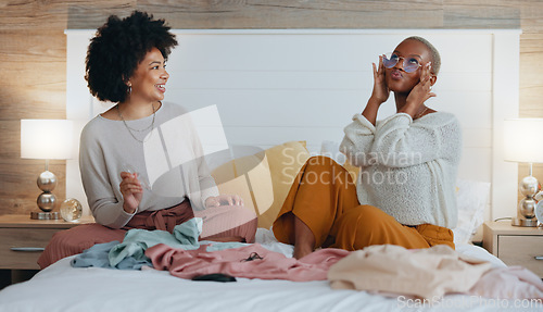 Image of Fashion, bedroom and friends choosing clothing for girls night out. Happy, smile and black woman on bed with friend sharing clothes. Women help with outfit choice for interview, social event or date.