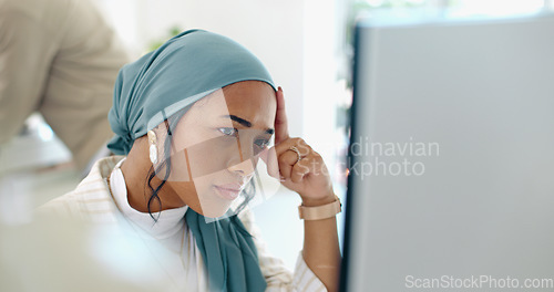 Image of Hijab, headache and business woman burnout at a office computer feeling anxiety and stress. Finance employee, islam and muslim female at work doing tax audit at a computer worried about mistake