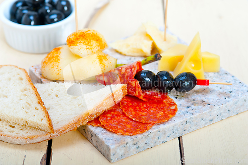 Image of mix cold cut on a stone with fresh pears