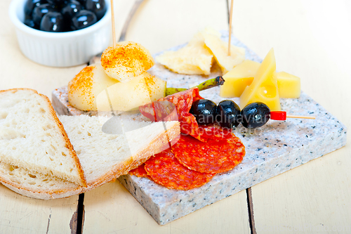 Image of mix cold cut on a stone with fresh pears