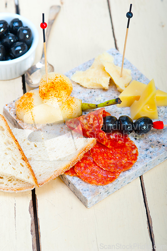 Image of mix cold cut on a stone with fresh pears