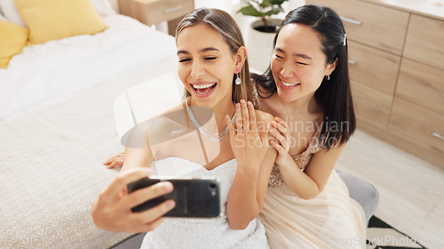 Image of Bride, bridesmaid and selfie with phone, wedding and ring with a smile to post on social media. Happy woman and asian friend excited for marriage celebration with fashion white dress in a bedroom