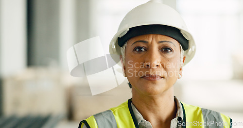 Image of Woman, serious face and construction worker, engineer at work site and business, building trade industry portrait. Mature person, safety helmet and professional, engineering and construction job.