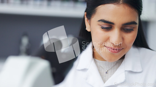 Image of Young scientist using a digital tablet and microscope in a lab. Female pathologist analyzing medical samples while doing experiments to develop a cure. Microbiologist conducting forensic research