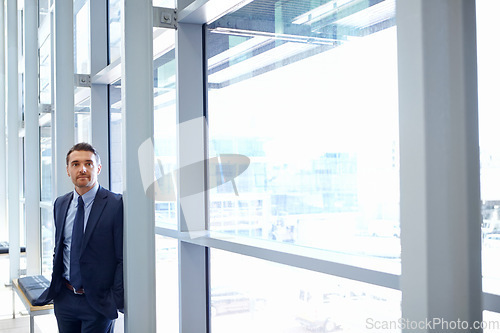 Image of Vision, mindset and window with a business man at work, standing in his office while thinking of an idea. Corporate, growth and future with a male employee leaning against a glass wall while working