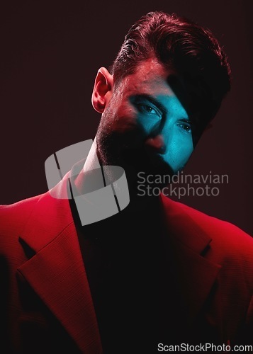 Image of Art, neon light and reflection, portrait of man with eyes in lighting on serious face and self expression. Futuristic fashion, male model and beauty with red and blue studio lights on dark background