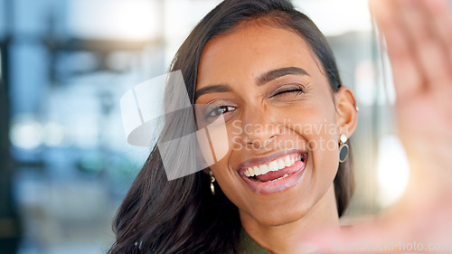 Image of Face of a happy business woman smiling, making funny expressions and creating a frame with her hand while standing in an office at work. Portrait of a smiling, carefree and cheerful female having fun