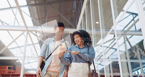 Image of Phone, black woman and man walking in a office building talking, reading or sharing online social media news. Social networking, mobile app or employees in communication or speaking of internet