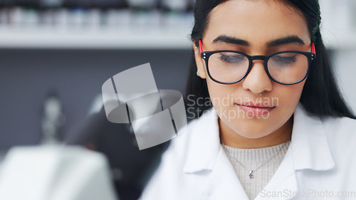 Image of Closeup of a young female scientist using a microscope analysing medical test results or samples in a research lab. Young woman doing forensic science and experiment to develop or discover a cure