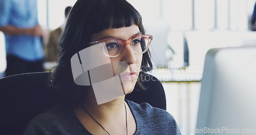 Image of Computer, serious and business woman working in an office at a startup company planning in an agency using internet. Employee, worker or female journalist brainstorming a story at her workplace