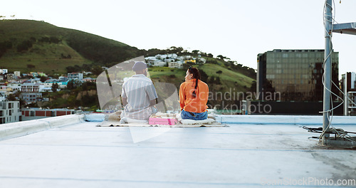 Image of Couple, city rooftop and relax together with love, friendship and romance during a sunset picnic. Urban friends, freedom and peace talking on lunch date in Cape Town South Africa cityscape background