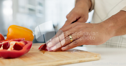 Image of Hands, food and nutrition with a man cooking in the kitchen while cutting vegetables on a wooden chopping board. Salad, health or diet with a chef preparing a meal while standing alone in his home