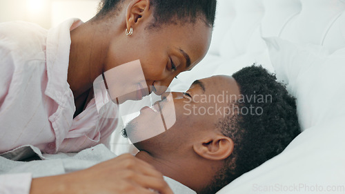 Image of Love, smile and happy intimate couple in bed in the morning while talk and bonding together. Black man and woman relax, conversation and communication trust, support and quality time in home bedroom