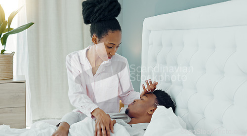 Image of Worry, cold and wife caring for sick husband in bed for illness, flu or virus while resting at home. Care, love and medical wellbeing with woman looking after man in bedroom for health