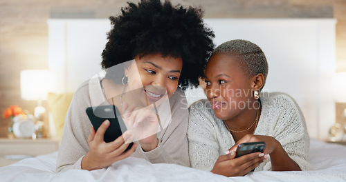 Image of Friends, phone and laugh in house bedroom, home interior or relax hotel with social media technology for dating app profile search. Smile, happy and comic women with mobile for fun communication