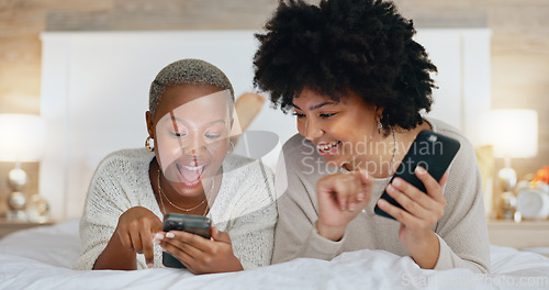 Image of Friends, phone and girls night in bedroom on social media. Happy, smile and black woman on bed with friend watching funny video. Women at sleep over, reading and exited for online dating app message.