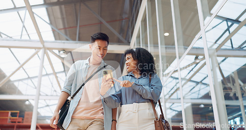 Image of Phone, black woman and man walking in a office building talking, reading or sharing online social media news. Social networking, mobile app or employees in communication or speaking of internet