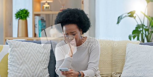 Image of Sad woman crying after reading a breakup text message on her phone. Young female, upset after receiving bad news that has brought her to tears. Suffering from loss or having an emotional breakdown