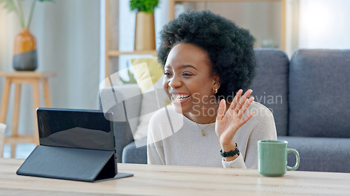 Image of Young woman on a video call on her laptop sitting at home home using her wireless headphones. Cheerful and beautiful African American female with afro talking to her friend online with a chat app