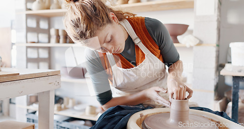 Image of Pottery, woman creative and mold clay art piece for class, hobby or relax in workshop or studio. Creativity, girl student or female sculptor use wheel spinning, shape art or ceramic design workspace.