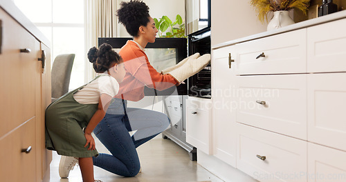 Image of Mother, girl and baking high five in kitchen, teamwork and celebration in home. Love, support and bonding mom and girl put tray in oven, cooking or collaboration, success or working together in house