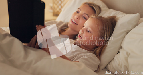 Image of Tablet, bed and relax with a girl and mother watching or streaming series on a subscription service while lying in a bedroom. Family, love and kids with a woman and daughter bonding together at home