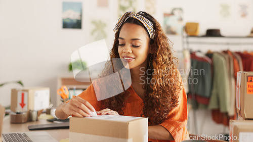 Image of Delivery, online order and woman in fashion on laptop while working at a boutique. Young, happy and African designer shipping stock of clothes in boxes and pc for service at a small business