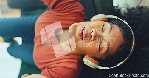 Image of Headphones, listening and dance of black woman on a sofa excited for subscription service, technology and home connection. Happy, relax and girl portrait dancing on couch while listening to music app