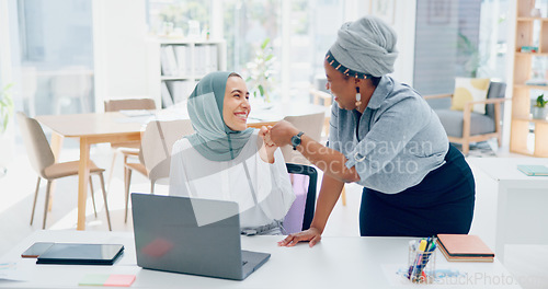 Image of Muslim, women team and laptop with support, advice or conversation for coaching in digital marketing. Black woman, coach or mentor for islamic woman in office with fist bump, learning and celebration