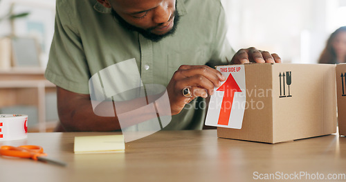 Image of Ecommerce, logistics and small business, man with package for delivery of unique product in home office. Success, online retail startup, and businessman putting label on box for international export