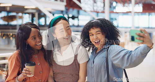 Image of Selfie, friends and social media with woman together posing for a photograph in a mall or shopping center. Phone, social media and smile with a happy female friend group taking a picture for fun