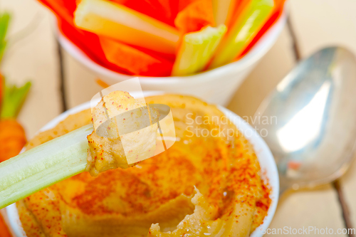 Image of fresh hummus dip with raw carrot and celery