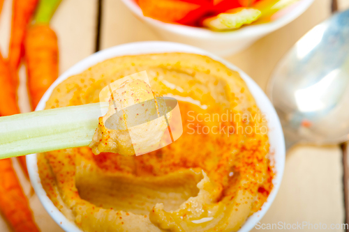 Image of fresh hummus dip with raw carrot and celery