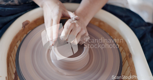 Image of Pottery, art and hands on a potter wheel with artist spinning clay in creative class, workshop or studio. Creativity, handicraft and closeup of a sculptor working on ceramic design, craft or creation