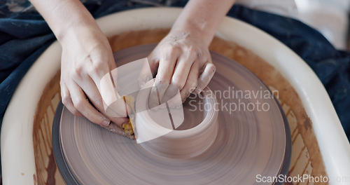Image of Pottery, art and hands on a potter wheel with artist spinning clay in creative class, workshop or studio. Creativity, handicraft and closeup of a sculptor working on ceramic design, craft or creation