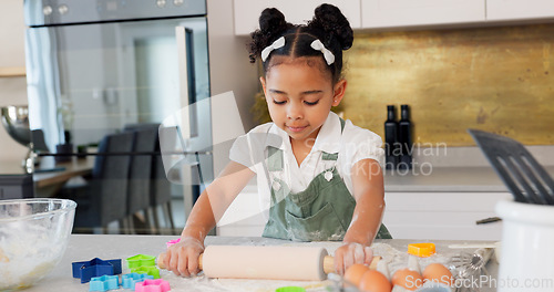 Image of Happy girl kids baking cookies with rolling pin in kitchen, house and home for childhood fun, learning and development. Young toddler child playing little cooking chef, baker and sweets dessert dough