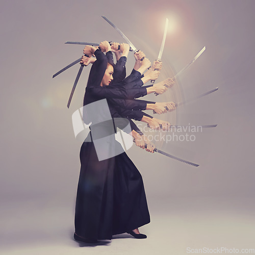 Image of Woman, warrior nun and sword in martial arts with motion blur strike against a studio background. Female wielding a sharp samurai blade, weapon or ninja fighter attacking in black cosplay