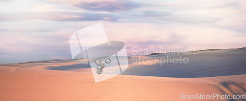 Image of Desert dunes, moto cross and sports adventure athlete doing a extreme jump with speed. Travel, sand and bike with energy of a man athlete cycling on dirt with challenge and sport race with freedom